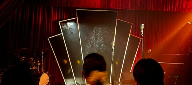 Black art deco on a black stage in a red lit environment